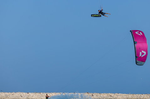 Tabla de kitesurf twin-tip Duotone Select SLS durante una sesión de kitesurf en la playa