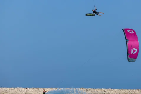Duotone Select SLS twin-tip kiteboard during kitesurfing at the beach under clear blue sky