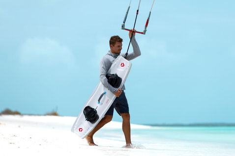 Tabla de kitesurf twin-tip Duotone Select Concept Blue durante kitesurf en playa tropical