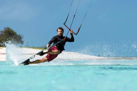 Tabla de kitesurf twin-tip Duotone Select Concept Blue durante kitesurf en una laguna tropical