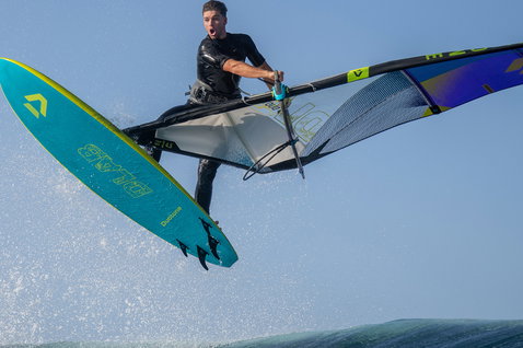 Duotone Cosmic D/LAB windsurf wave board during wave riding on the ocean in teal
