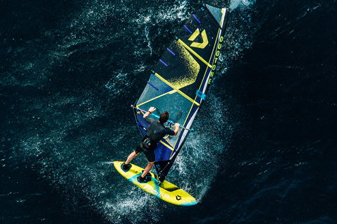 Duotone Skate D/LAB freestyle windsurf board during windsurfing on open ocean, aerial top-down view