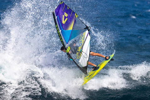 Duotone Super_Hero D/LAB wave windsurf sail during wave riding on the ocean in navy, purple and sky blue