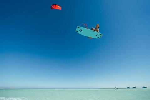 Tabla de kitesurf twin-tip Duotone Soleil Concept Blue durante el kitesurf sobre el océano