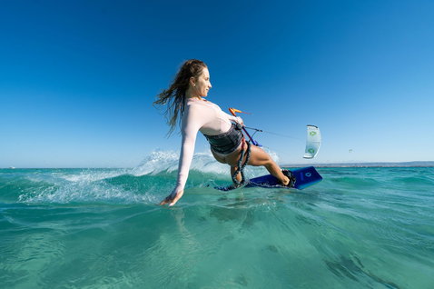 Tabla de kitesurf twin-tip Duotone Soleil Concept Blue durante la práctica de kitesurf en el océano turquesa