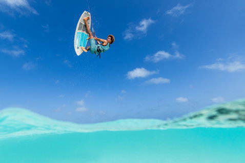 Tabla de surf de cometa sin correas Duotone Volt D/LAB durante la práctica de kitesurf en olas sobre océano turquesa tropical