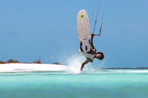 Tabla de kitesurf Duotone Whip D/LAB durante strapless freestyle sobre una laguna turquesa