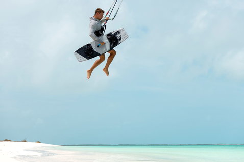 Duotone TS Big Air SLS Kiteboard beim Kitesurfen mit Big-Air-Sprung über einem tropischen Strand