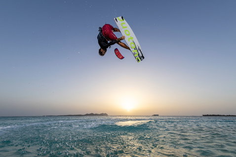 Duotone TS Big Air SLS Twintip Kiteboard beim Big-Air-Kitesurfen über dem Meer bei Sonnenuntergang