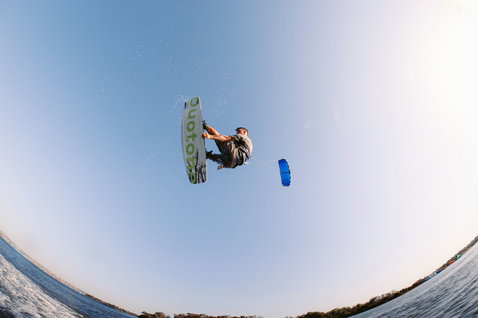 Tabla de kitesurf twin-tip Duotone TS Freestyle SLS durante una maniobra de freestyle sobre agua plana