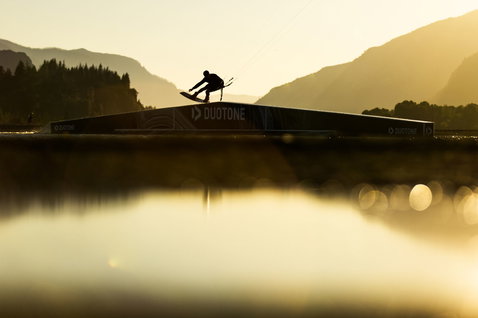 Tabla de kite Duotone TS Park durante práctica de wakestyle en un kicker de park al atardecer en lago de montaña