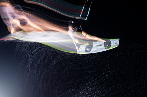 Tabla de kitesurf twin-tip Duotone Soleil SLS durante una sesión de kitesurf en el océano de noche