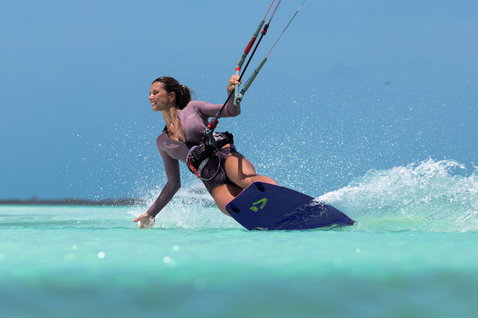 Tabla de kitesurf twin-tip Duotone Soleil SLS durante kitesurf en una laguna tropical turquesa