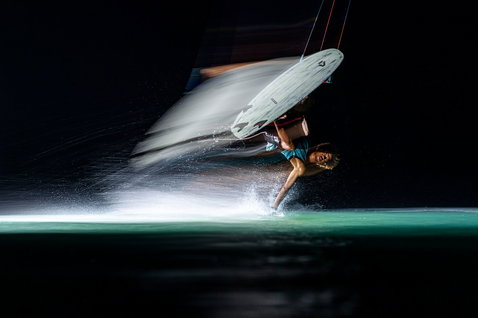 Tabla de surf strapless freestyle Duotone Provoke 5'1" durante kitesurf en el océano de noche