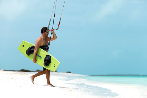 Planche de kitesurf twin-tip Duotone Entity Ergo Jaime SLS en vert citron lors de kitesurf sur la plage