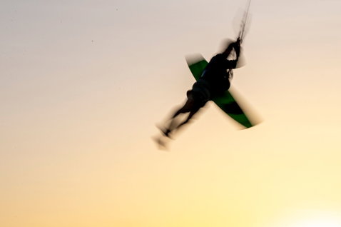 Duotone Entity Ergo twin-tip kiteboard lors d'une session freestyle au coucher du soleil