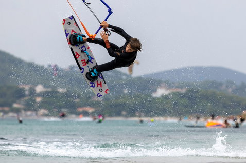 Tabla de kitesurf twin-tip Duotone Shred 128 cm durante kitesurfing, joven rider en el aire sobre el mar
