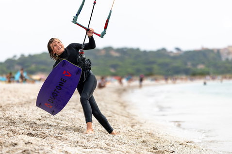 Duotone Shred tabla de kitesurf twin-tip 128cm en violeta oscuro durante kitesurf en la playa