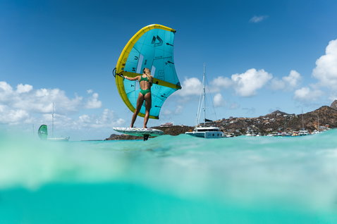Duotone Skybrid D/LAB foil board during wing foiling in a tropical Caribbean bay in teal and white