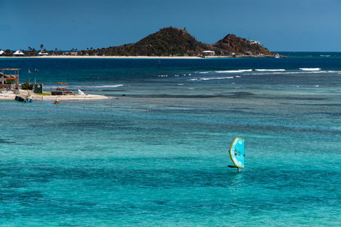 Duotone Skybrid D/LAB foil board during wing foiling in a tropical turquoise lagoon