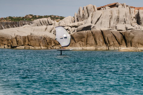 Duotone Skybrid Air wing foil board during wing foiling at a rocky coastal bay